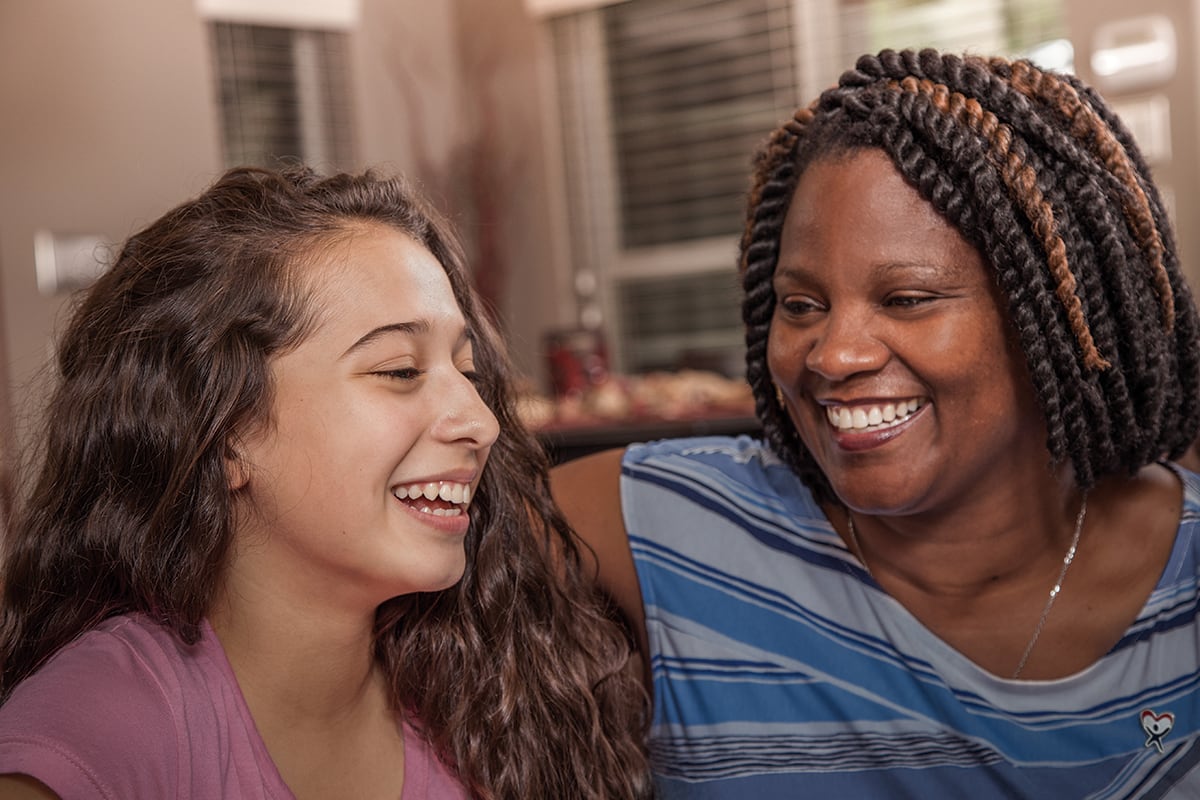 Young woman laughs with teen