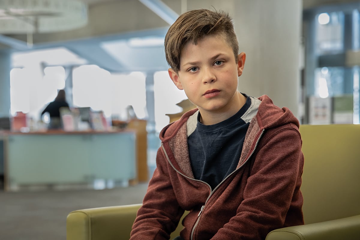 Young boy sites on green chair